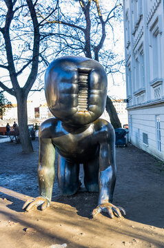 Prague, Czech Republic - February 15, 2019: One of David Cerny's large bronze crawling baby sculptures with a barcode face sits on the Vltava embankment.