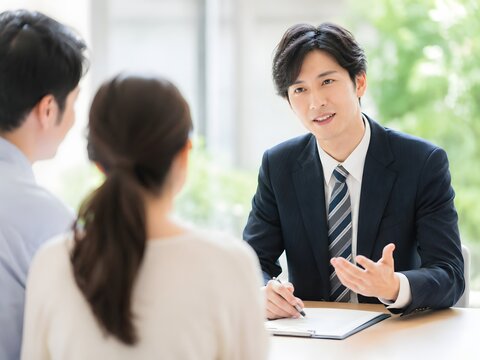 Educational consultant in suit advising a couple at interview