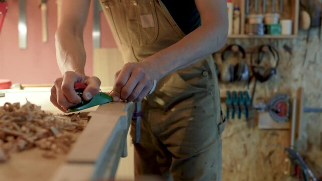 Creative working process in carpentry, carpenter manufacturing furniture, working with plane on chair legs, private production of wooden products, handyman shaping details with hand plane instrument.
