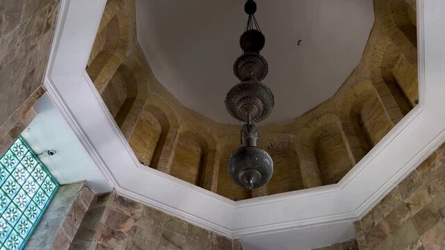 Bronze chandelier in Islamic interior design with metal accessories ceiling traditional architecture Isfahan Iran Shiraz mansion indoor geometric tile rotating scenic pattern aesthetic art of culture