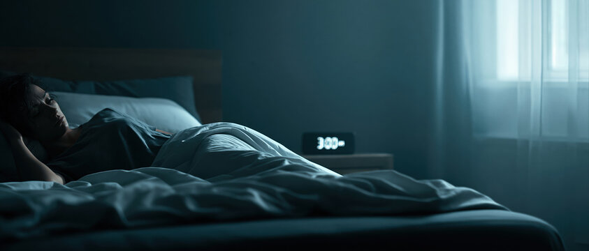 Restless figure lies awake at 3AM in a dimly lit bedroom, blue moonlight filtering through curtains. Ideal for sleep health, mental wellness, insomnia awareness, and stress campaigns.