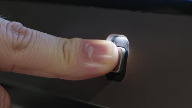 Pressing index finger entering from left, pressing power button on dark glossy panel, powering unit