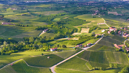 Fototapeta premium Aerial View of Rolling Vineyard Hills and Rural Village in Piedmont Italy