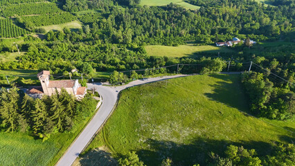 Fototapeta premium Aerial View of a Historic Church and Winding Road in Piedmont
