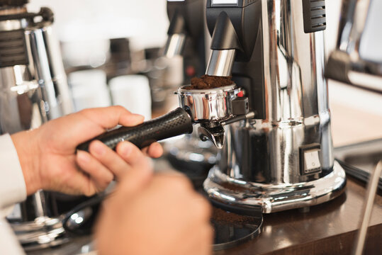 グラインダーでコーヒー豆を挽くバリスタの手元