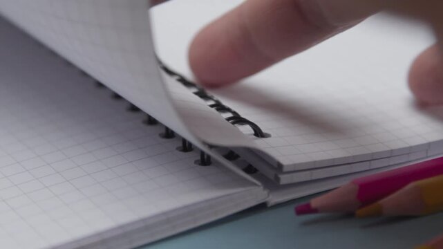 Close Up of a Hand Opening an Exercise Book on a Desk, Representing Back to School, Education, Classroom Learning, School Supplies, and Student Study