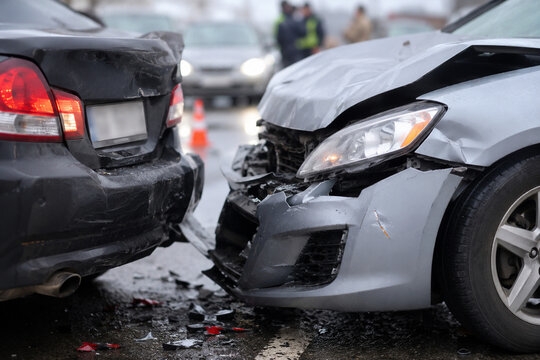 Damaged cars after rear end collision on wet road