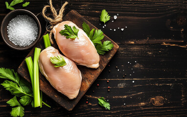 Fototapeta premium raw chicken fillets on wooden cutting board, top view