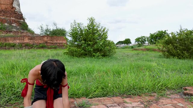 Young Boy in Traditional Martial Arts Attire Praying at Ancient Temple Ruins