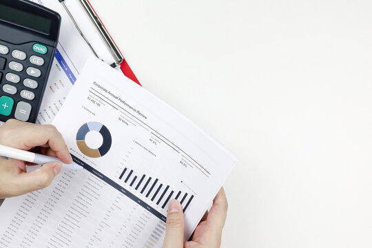 Hand reviewing a corporate annual performance review document near copy space. Concept of financial data analysis, business evaluation, tax audit, and budget planning.