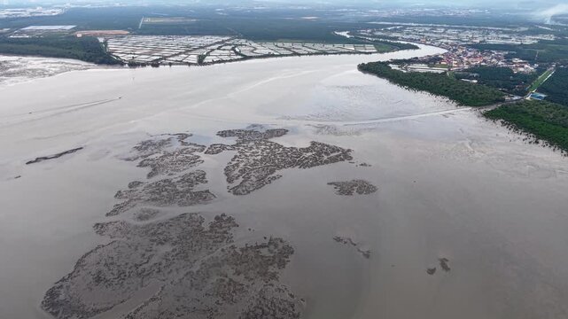 Aerial footage showing tidal mudflats, river mouth and nearby village at Sungai Udang