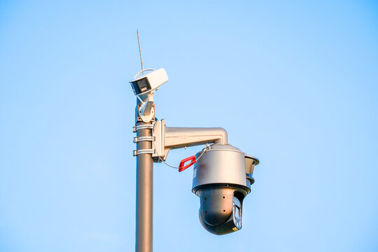 Two Different Security Cameras Mounted On A Pole Outdoors