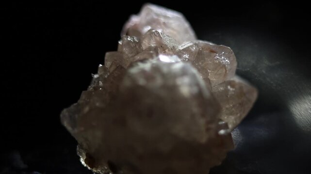 Rose quartz natural crystal on black background with backlight. Slow zooming video on Canga rosa also called pink quartz.