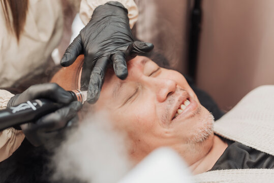 Middle-aged man enjoying a hydradermabrasion facial treatment that deeply cleanses, exfoliates, and hydrates the skin for a refreshed and healthier complexion.