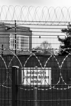 Warning sign behind barbed wire at a juvenile detention center in Germany
