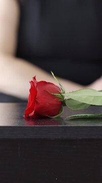 Coffin, flower and man at funeral with respect, grief or loss at family service for burial.Hand, mourning and male person with red roses on casket for remembrance at memorial at graveyard
