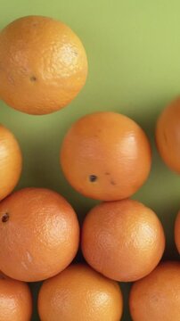 Group of oranges falling on a green background