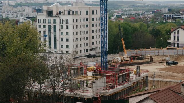 Timelapse showing the busy construction site of a new building, with workers and machinery actively working on the foundation and structure against an urban cityscape backdrop