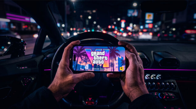 Grand Theft Auto VI logo displayed on a smartphone screen held by hands inside a car at night. GTA 6 announcement splash screen for upcoming Rockstar game. Point of view mobile gaming concept 2025.