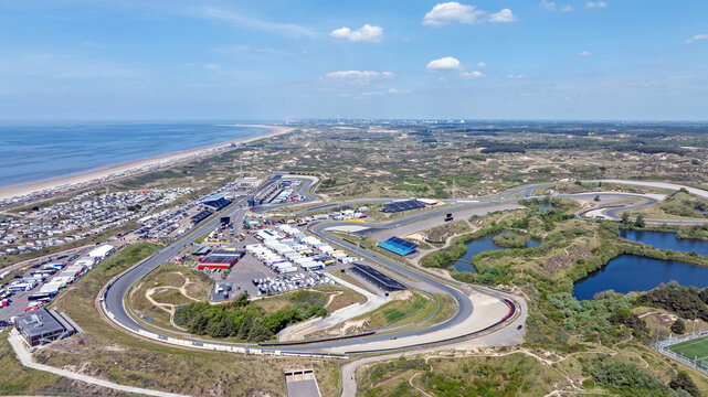 Aerial view of Circuit Zandvoort race track surrounded by coastal dunes, sandy beaches, and the North Sea in Zandvoort, North Holland, Netherlands.