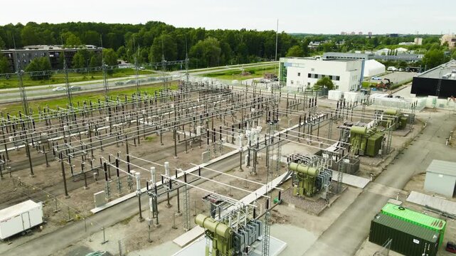 High voltage electrical substation with power lines, insulators, and transformers for distributing and transmitting electricity, representing an essential component of the modern power grid