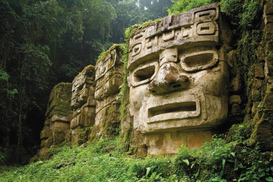 Ancient ruin stone head jungle temple mossy stone carved face rainforest archeology travel heritage South America