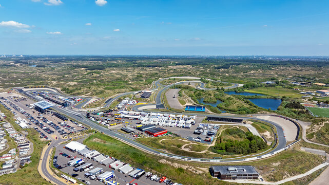 Aerial view of Circuit Zandvoort race track surrounded by dunes and greenery with parking areas and support structures in Zandvoort, North Holland, Netherlands.