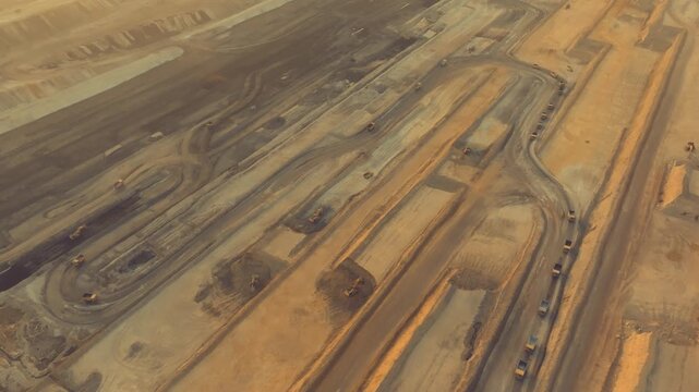 Numerous dump trucks and excavators moving earth in a vast Thar coal mine in Pakistan