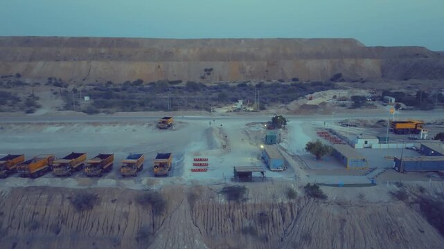 Aerial - row of yellow haul trucks parked at coal mine base Thar Pakistan