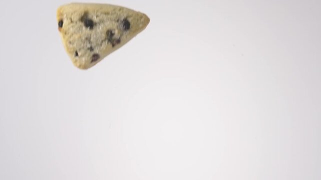 Shower of crumbly fruit-studded scones falling on bright white studio backdrop in slow motion. blueberry brand commercials, healthy breakfast content, farmers market bakery posts.