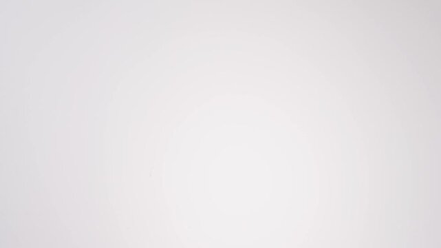 Colorful sprinkle-topped donuts raining down on white seamless backdrop in cinematic slow motion. kids birthday party reels, celebration content, festive party posts.