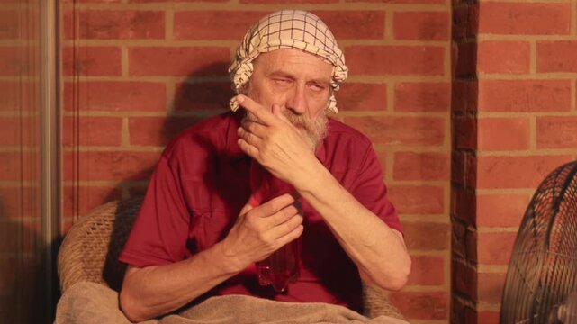 Elderly man struggling with extreme summer heatwave on his city apartment balcony