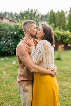 Romantic Couple Kissing During Pregnancy Outdoors