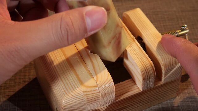 Creative artisan craftsman hands using gouge to carve intricate details traditional chinese stone emblem stamp seal. Skilled craft worker hand-carving details at workshop and tool display