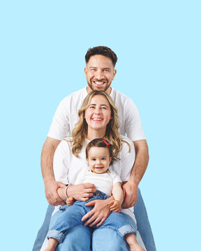 A cheerful young family with a happy, baby in photo studio. The parents are smiling.