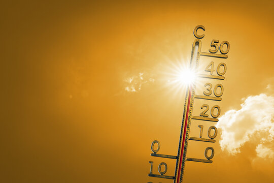 Blue sky on a hot summer day with sun and a thermometer. Extremely hot weather forecast.