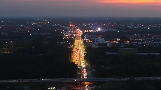 Drone footage of vehicle traffic on a lit road in Jawi, Penang at dusk.