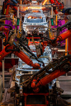 Robotic arms are welding body weld points on an automated production line at an automobile factory.