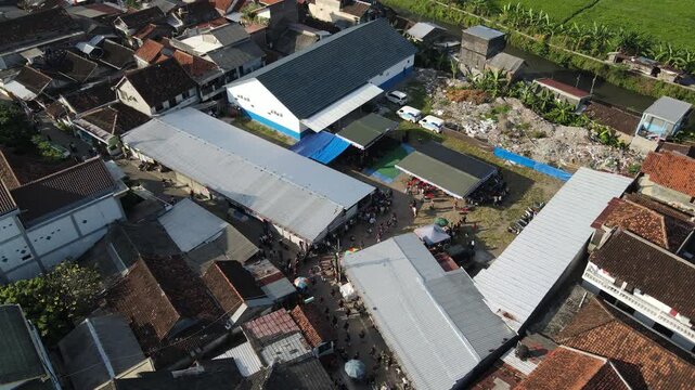 Aerial footage of a cultural procession or Javanese traditional festival, amidst the density of urban villages.