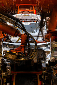 Robotic arms are welding body weld points on an automated production line at an automobile factory.