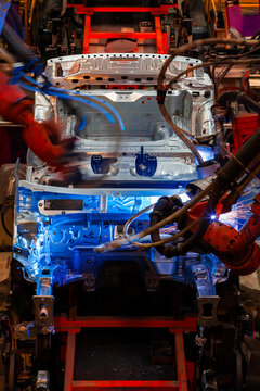 Robotic arms are welding body weld points on an automated production line at an automobile factory.