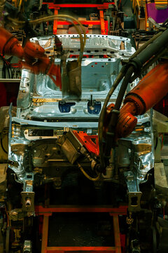 Robotic arms are welding body weld points on an automated production line at an automobile factory.