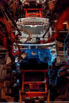 Robotic arms are welding body weld points on an automated production line at an automobile factory.