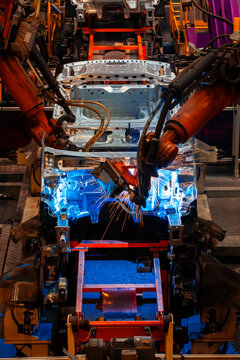 Robotic arms are welding body weld points on an automated production line at an automobile factory.