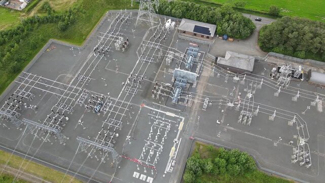 Aerial drone view of electrical substation and high-voltage transmission pylons in Scotland