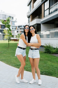Customer Young Sisters Posing in Residential Courtyard