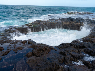 Fototapeta premium Powerful Atlantic waves filling a natural volcanic rock pool on the coast of Gran Canaria, Canary Islands, Spain