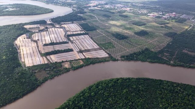 Aerial shot shows a winding river next to industrial complexes