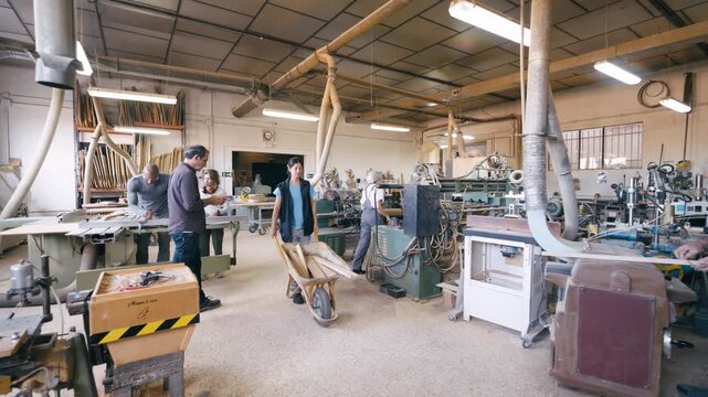 Group of woodworkers collaborating in a bustling carpentry workshop. Professional artisans using industrial machinery and tools for crafting