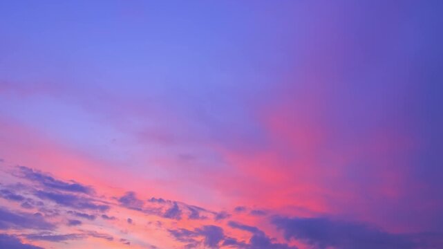 Morning or evening sky. Colorful clouds fill twilight with gradients of purple, pink and orange during sunset or sunrise. Natural background. Beauty in nature. Expressive cloudscape. High quality 4K.